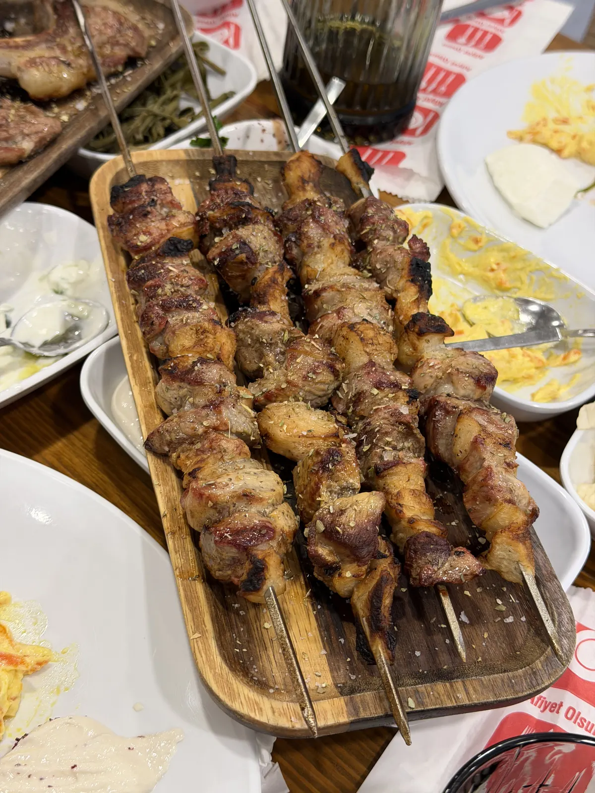 Tahta servis üzerinde odun ateşinde pişmiş kuzu et şişleri